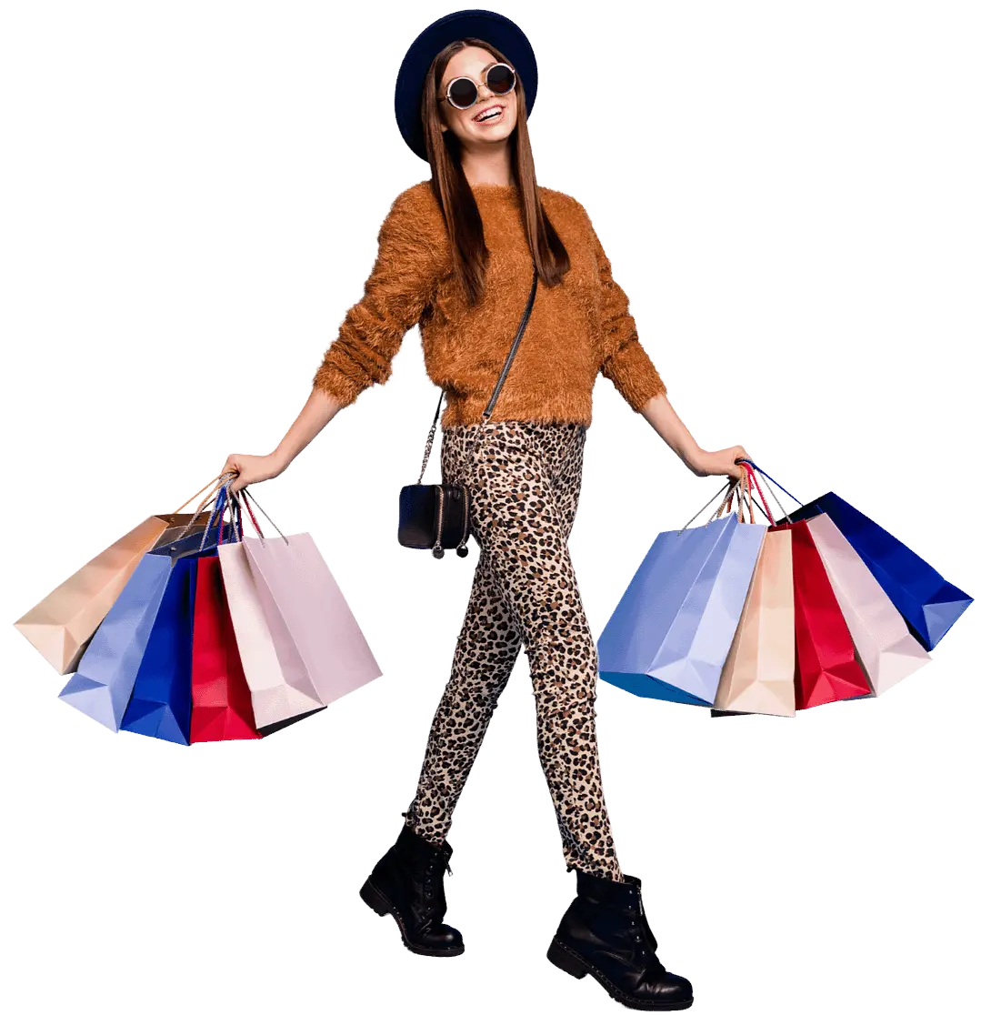 full length photo of a woman smiling as she steps forward, holding several brightly coloured shopping bags in each hand